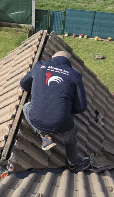 Couvreur-zingueur au travail sur le faîtage d'une toiture dans le Val-d'Oise