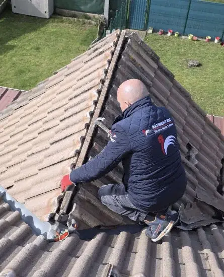 Artisan sur le faîtage d'une toiture avec chien-assis — BS Couvreur 95