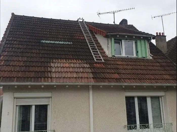 Démoussage de toiture en cours sur un pavillon du Val-d'Oise